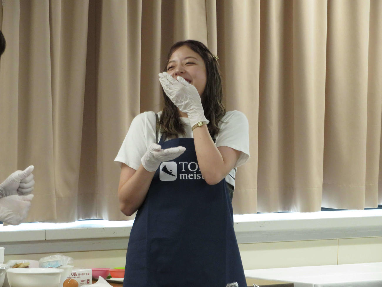 おからマルシェイベントにゲスト出演した元乃木坂46の和田まあやはドーナツ作り中におからをなめて笑う（撮影・望月千草）