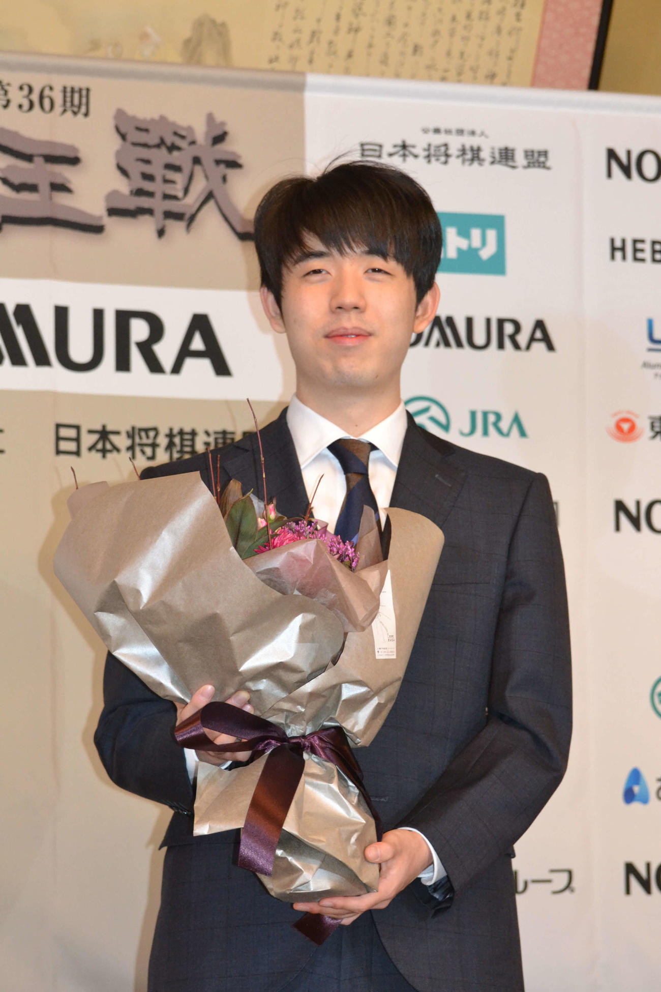 一夜明け会見で花束を贈呈された藤井聡太竜王