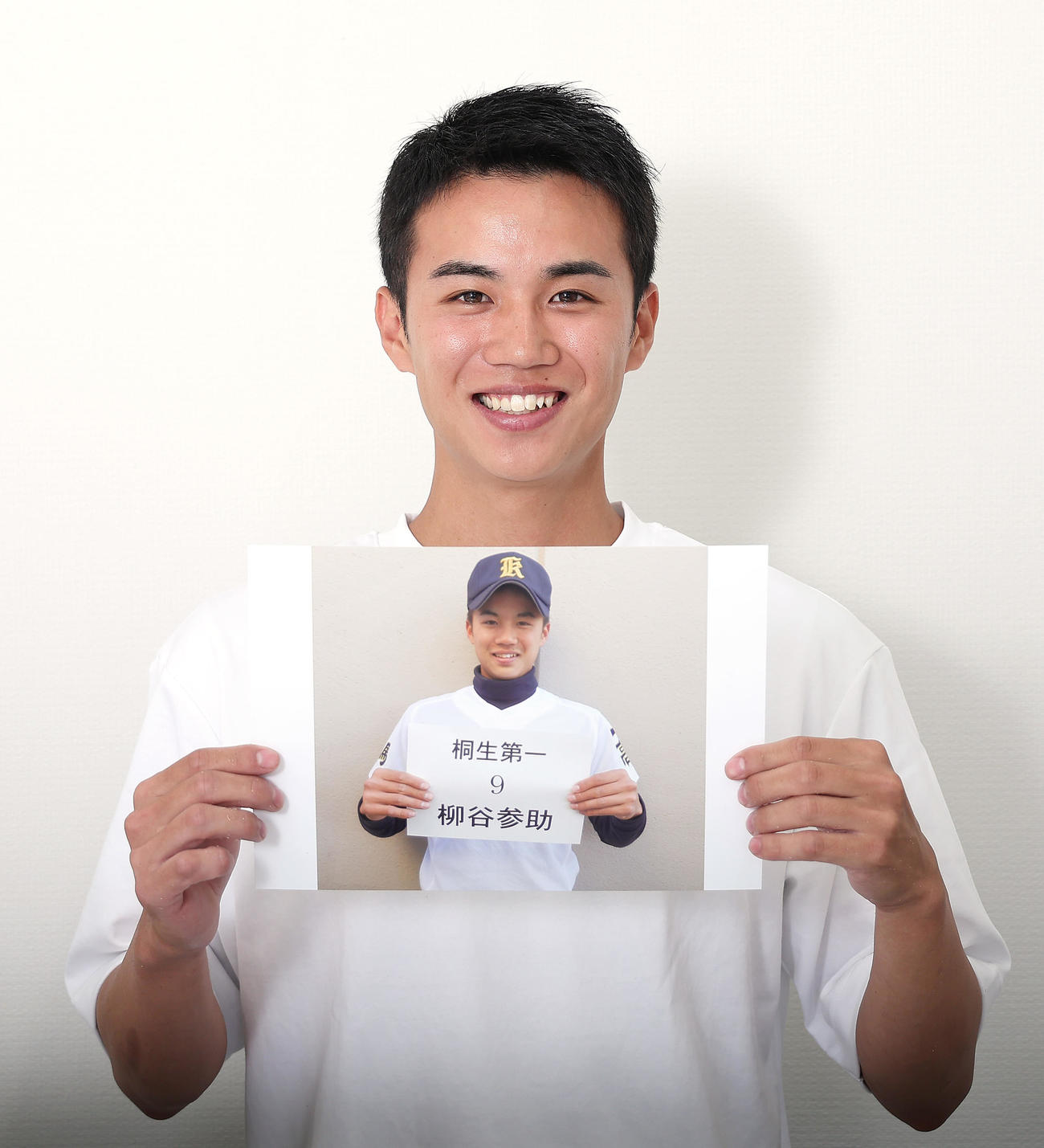 元甲子園球児の柳谷参助。自身の当時の顔写真を手に笑顔（撮影・足立雅史）