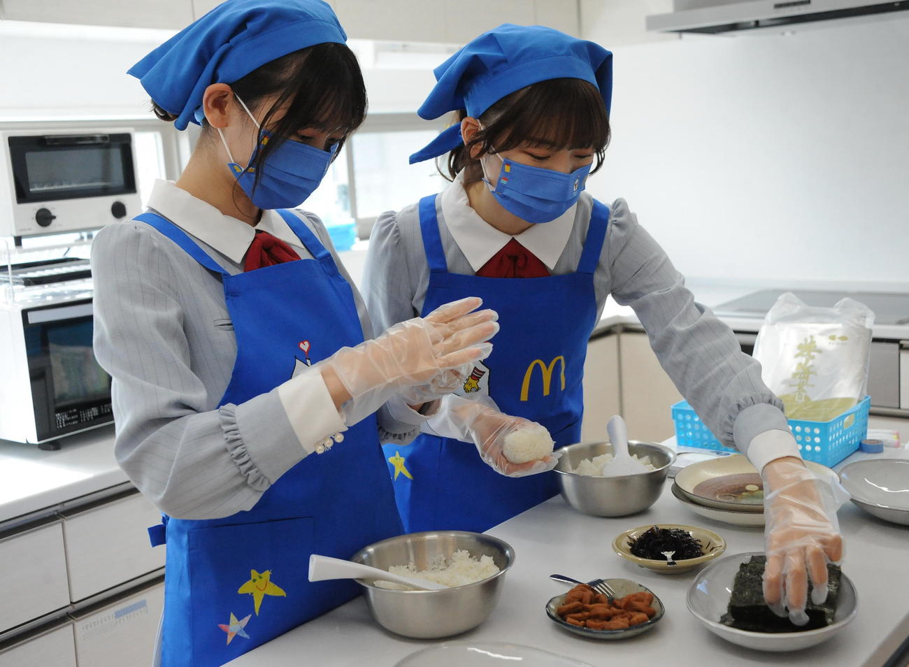 施設利用者のために新米「ときむすめ」でおにぎりを作る佐藤（左）と藤崎