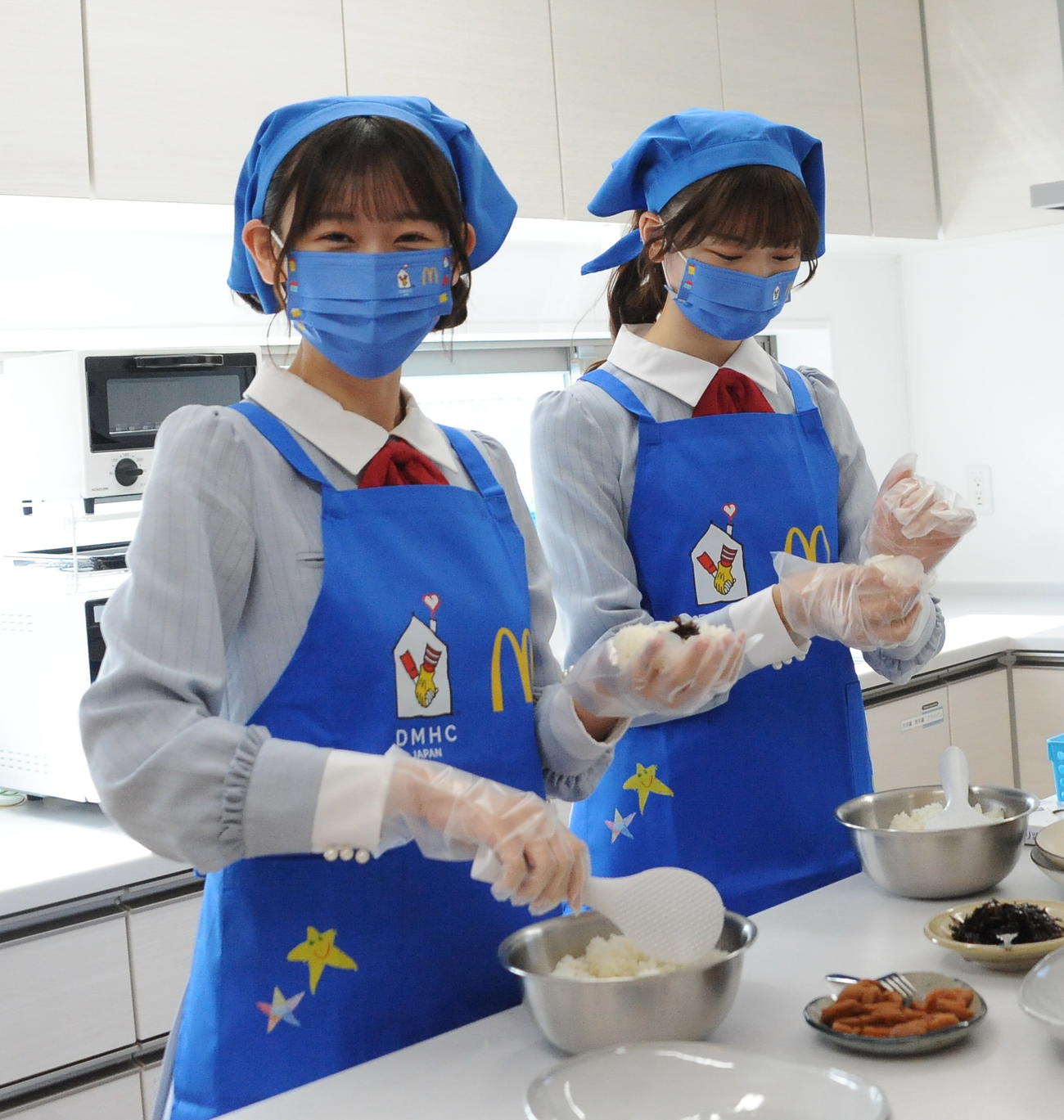 施設利用者のために新米「ときむすめ」でおにぎりを作るNGT48の佐藤（左）と藤崎