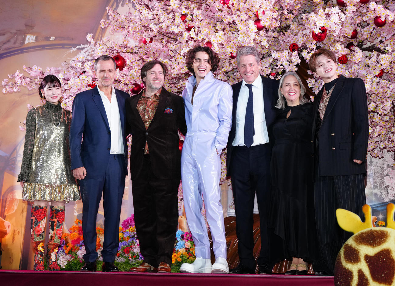 映画「ウォンカとチョコレート工場のはじまり」マジカル・チョコレート・ナイトに臨み、写真に納まるティモシー・シャラメ（中央）ら。左からセントチヒロ・チッチ、プロデューサーのデイビッド・ヘイマン氏、ポール・キング監督、1人おいてヒュー・グラント、プロデューサーのアレクサンドラ・ダビーシャー氏、花村想太（撮影・江口和貴）