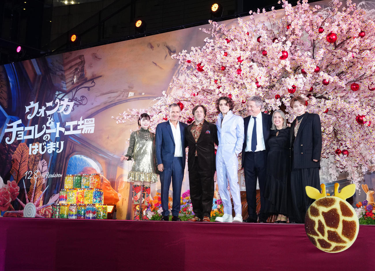 映画「ウォンカとチョコレート工場のはじまり」マジカル・チョコレート・ナイトに臨み、写真に納まるティモシー・シャラメ（中央）ら。左からセントチヒロ・チッチ、プロデューサーのデイビッド・ヘイマン氏、ポール・キング監督、1人おいてヒュー・グラント、プロデューサーのアレクサンドラ・ダビーシャー氏、花村想太（撮影・江口和貴）