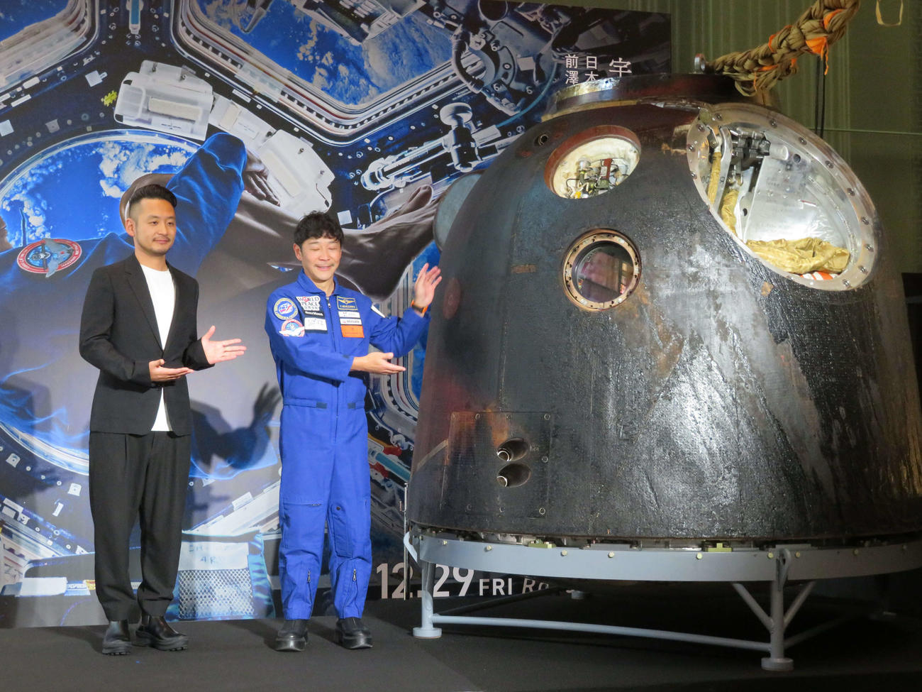 ドキュメンタリー映画「僕が宇宙に行った理由」公開を記念した特別展で日本初展示された、ソユーズの帰還モジュールを横に、笑顔の平野陽三監督（左）と前澤友作氏（撮影・村上幸将）