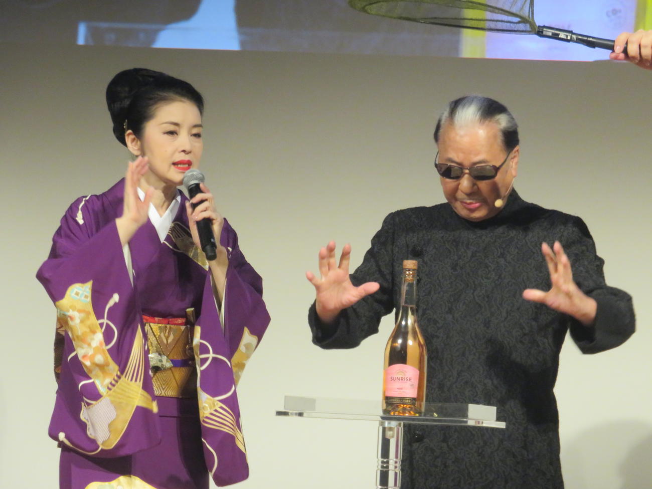 藤あや子（左）とともにハンドパワーを送って、手を触れずにシャンパンの栓を抜こうとするMr.マリック