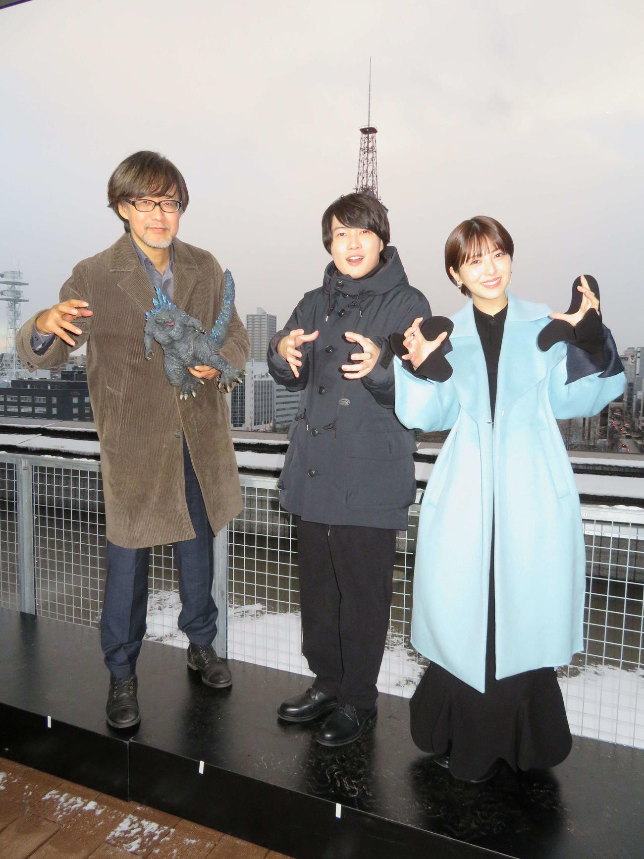91年「ゴジラVSキングギドラ」でゴジラが迫った、さっぽろテレビ塔をバックにゴジラポーズをする、左から山崎貴監督、神木隆之介、浜辺美波（撮影・村上幸将）