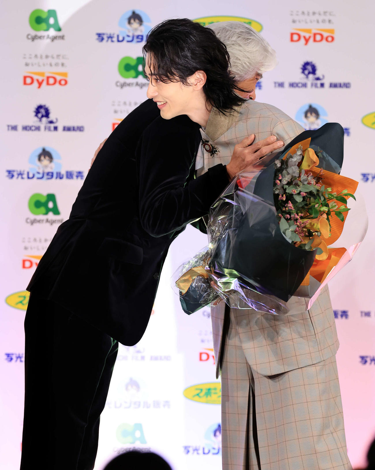 サプライズ登壇の佐藤浩市（左）から花束を贈られ、抱擁される主演男優賞の横浜流星（撮影・浅見桂子）