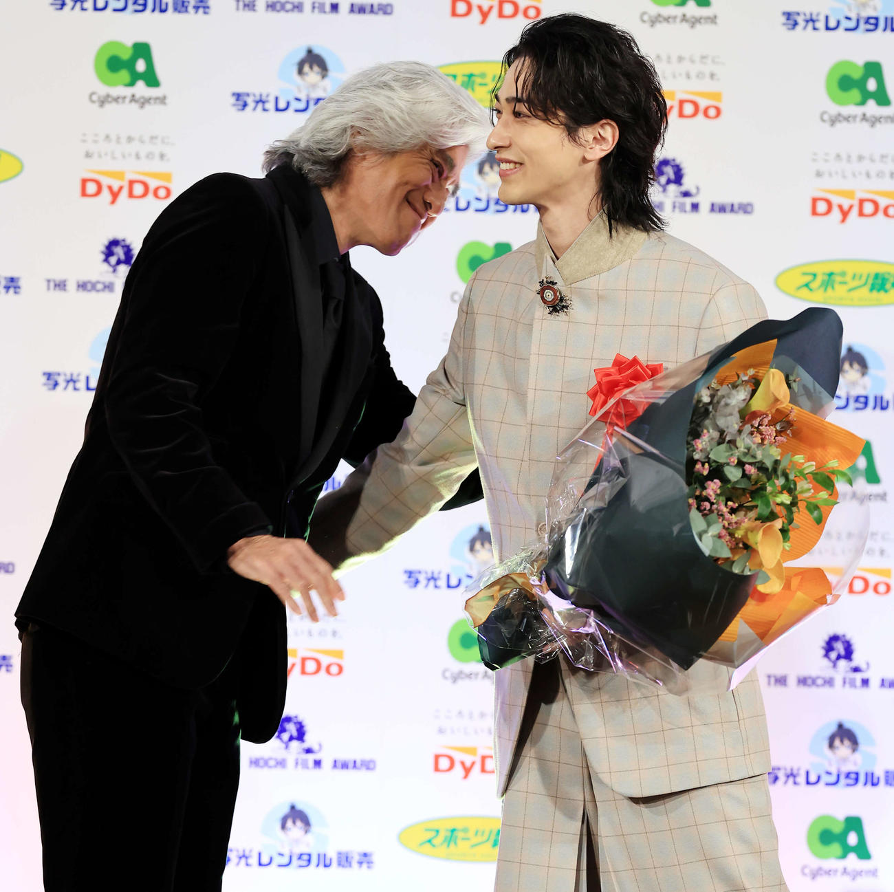 報知映画賞主演男優賞の横浜流星（右）は、サプライズ登壇の佐藤浩市から花束を贈られ笑顔（撮影・浅見桂子）