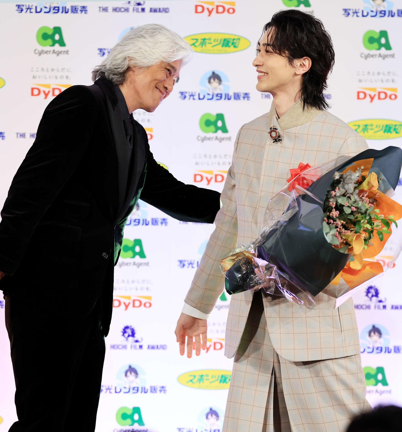 報知映画賞主演男優賞の横浜流星（右）は、サプライズ登壇の佐藤浩市から花束を贈られ笑顔（撮影・浅見桂子）