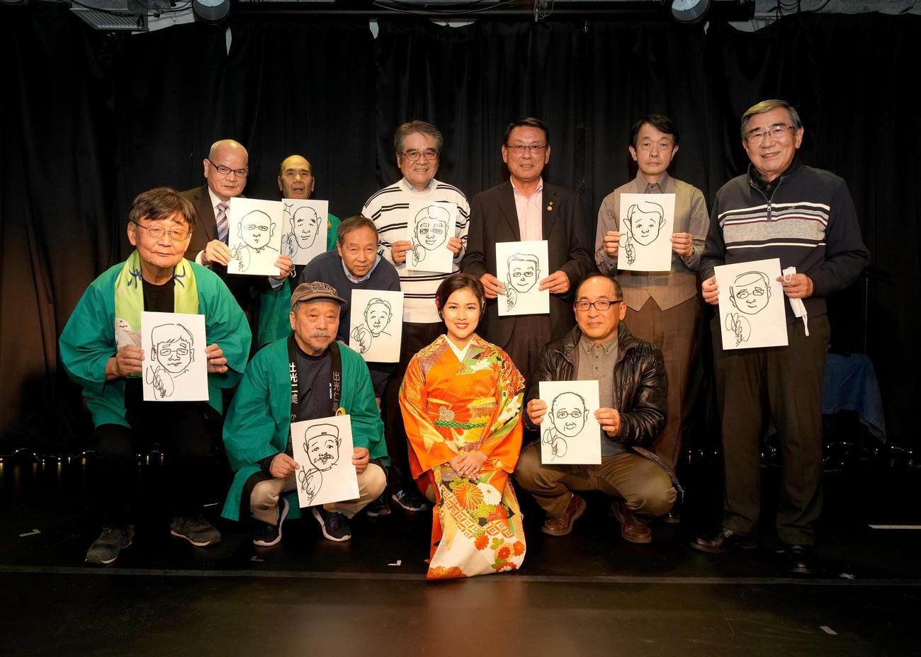 歌唱しながらファン10人の似顔を描いた出光仁美（前列中央）