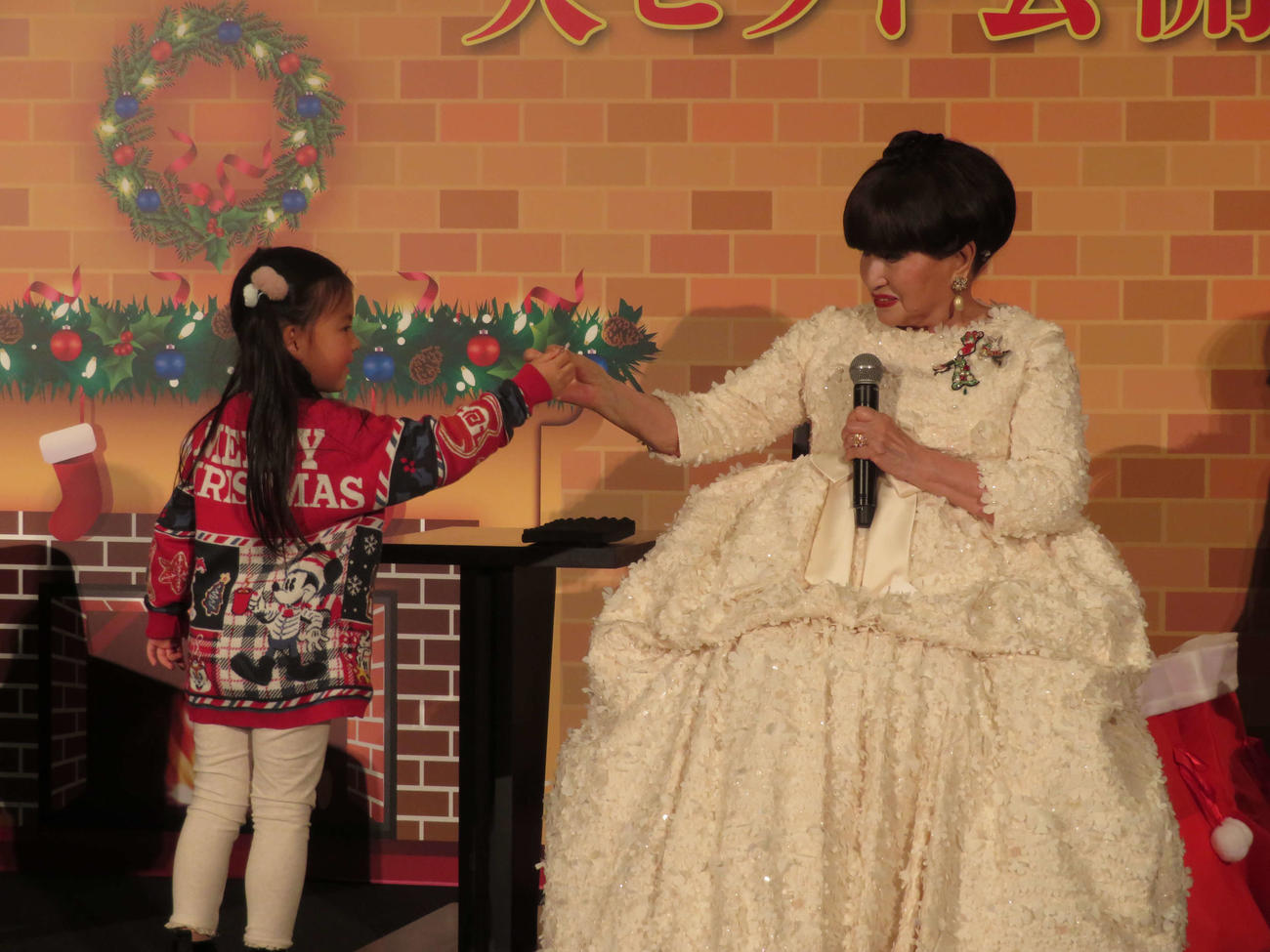 映画「窓ぎわのトットちゃん」公開記念ティーチイン付き舞台挨拶に登壇し、子どもに頭から取り出したあめ玉を手渡す黒柳徹子