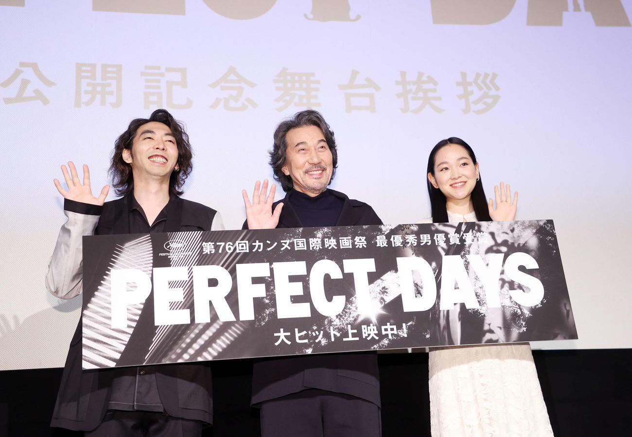 手を振り写真に納まる、左から柄本時生、役所広司、中野有紗（撮影・鈴木正人）