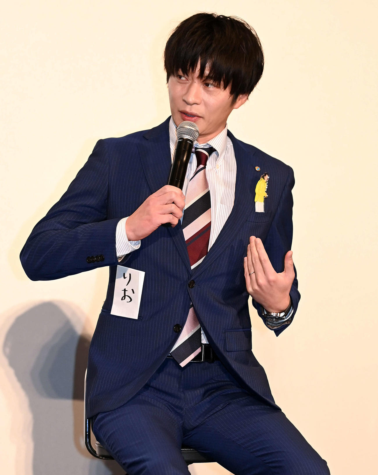 体調不良のため欠席となった吉田剛太郎のバッジを胸に同じく欠席の内田理央の名札をポケットに忍ばせて登壇した田中圭（撮影・たえ見朱実）