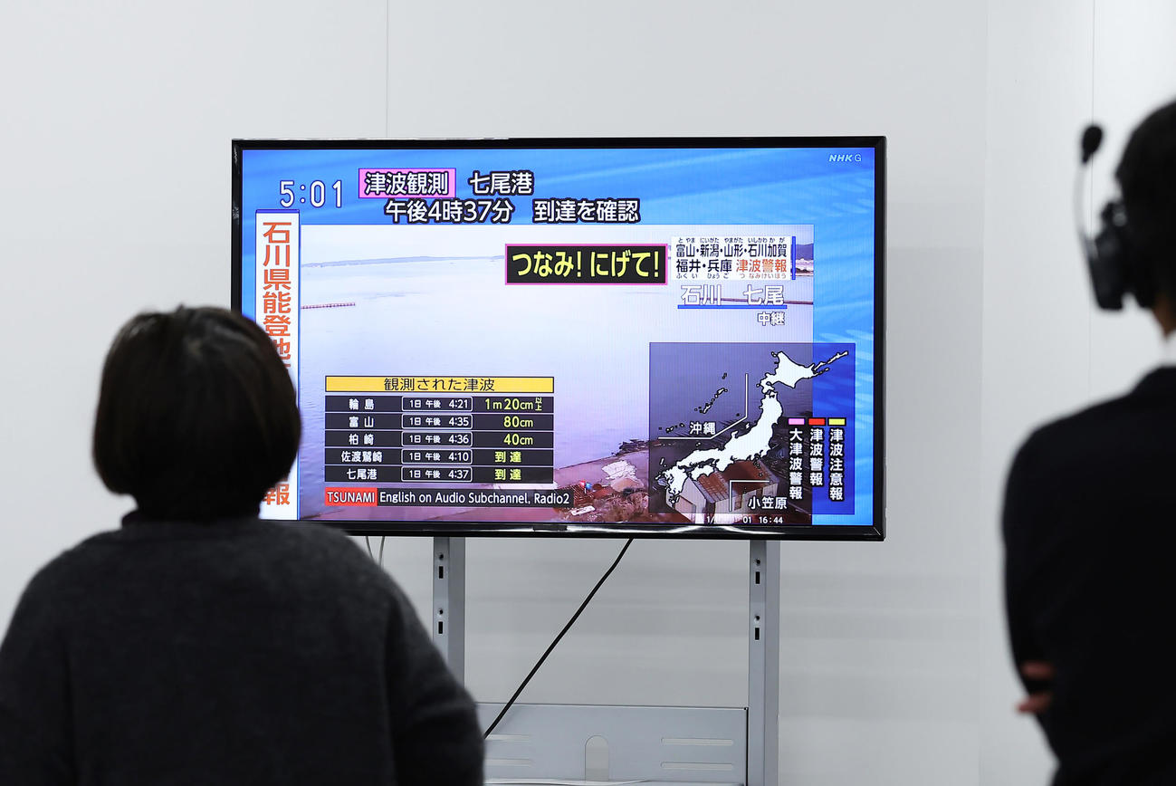 石川県での地震の情報を伝える会見場のテレビを見つめる報道陣ら（撮影・足立雅史）