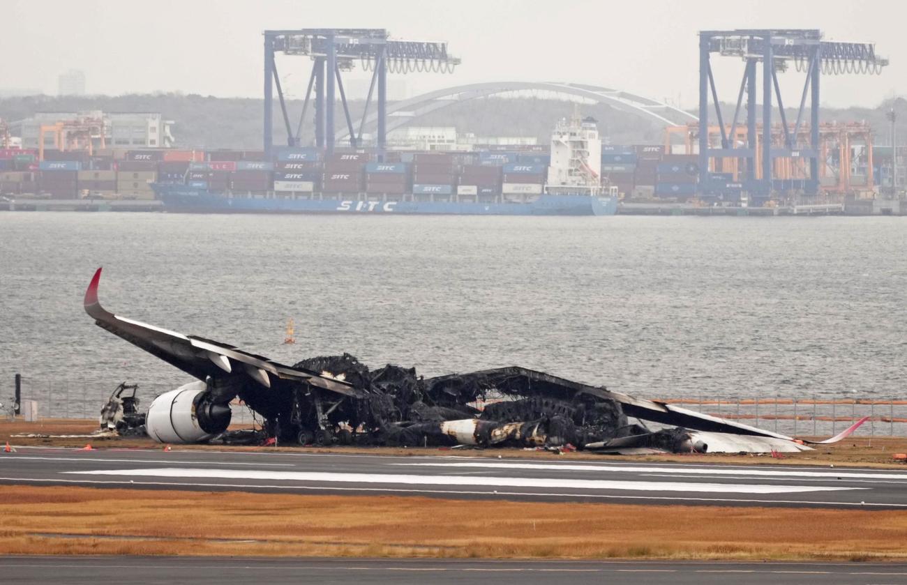 羽田空港の滑走路で炎上し、焼け焦げた日航機（共同）