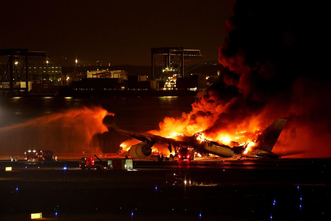 羽田空港のC滑走路で炎上する日航516便（ロイター）
