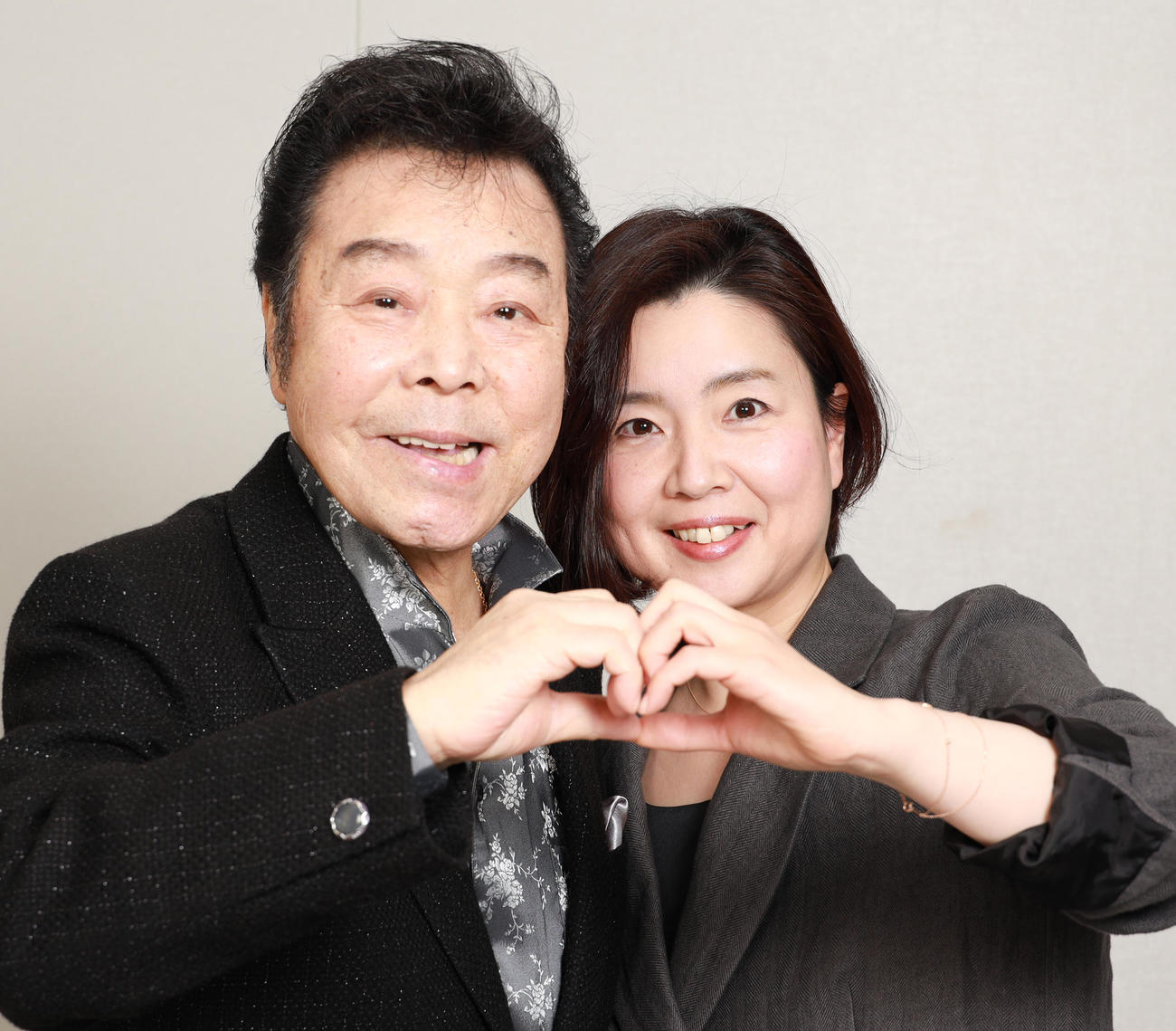 ハートマークを作る冠二郎さん（左）と妻の味菜子さん（2020年4月8日撮影）