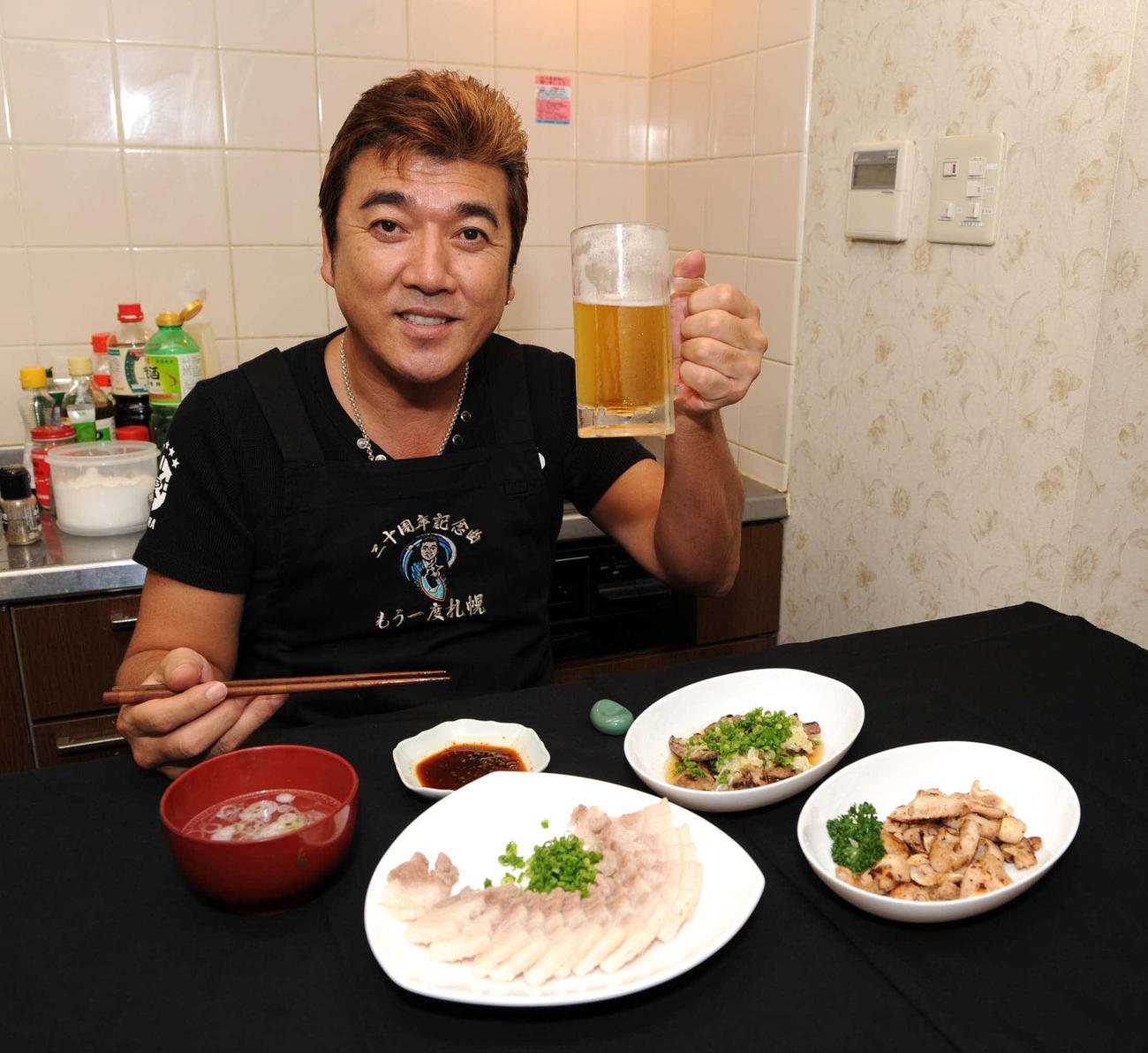 豚ざんまいの4品を前にビールで乾杯する小金沢昇司さん（2008年9月撮影）