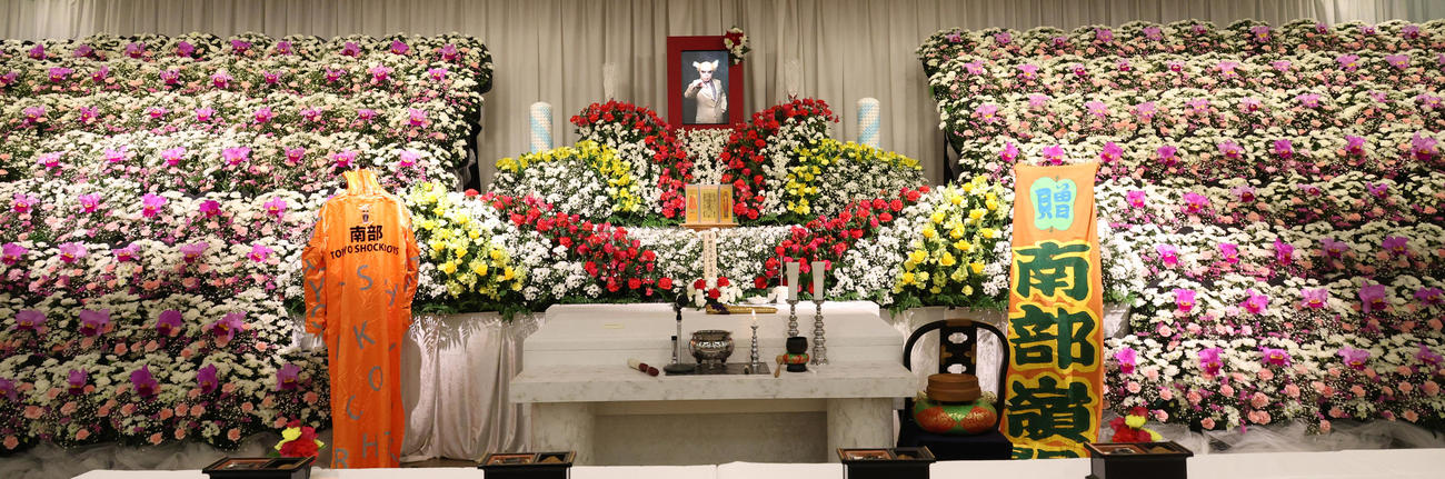 カラフルな花が飾られた南部虎弾さんの祭壇（撮影・中島郁夫）