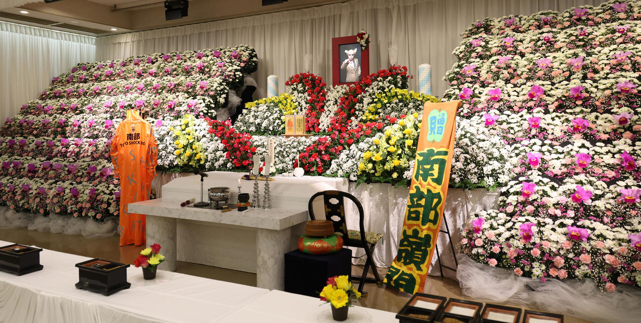 カラフルな花が飾られた南部虎弾さんの祭壇（撮影・中島郁夫）