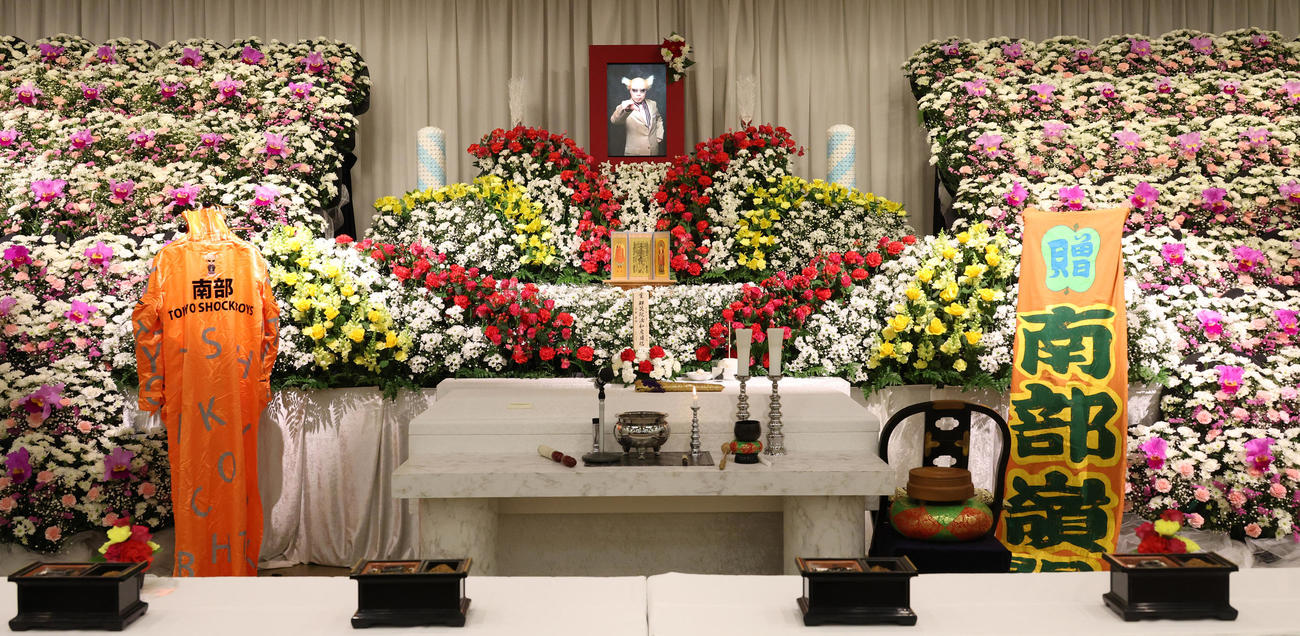 カラフルな花が飾られた南部虎弾さんの祭壇（撮影・中島郁夫）