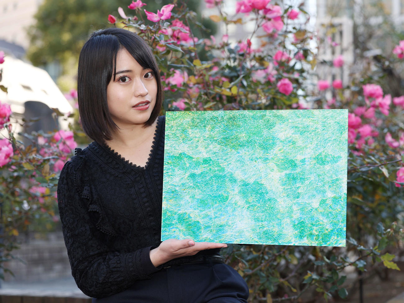 作品を手に笑顔を見せるかざり（撮影・宮地輝）