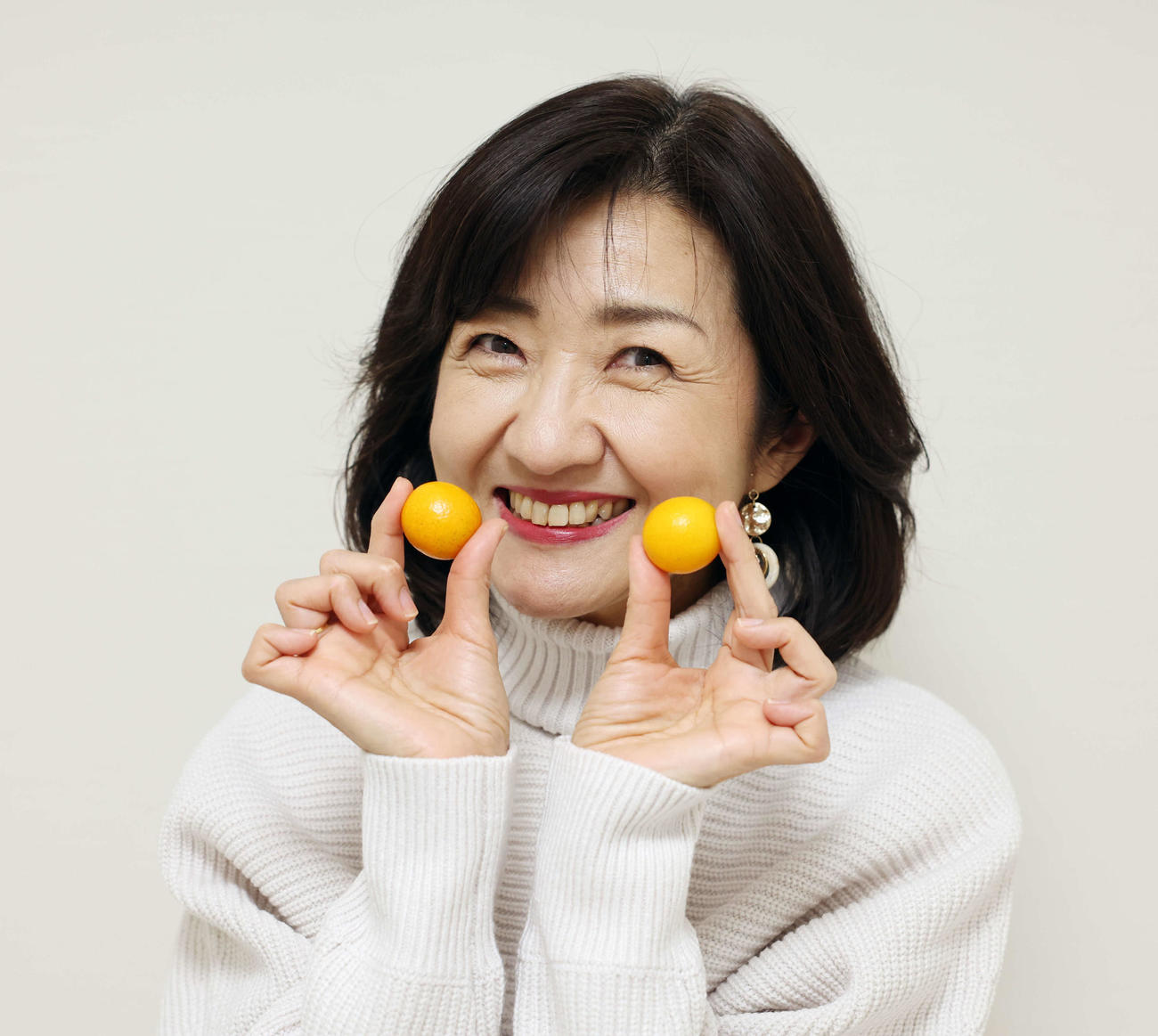 金柑を手にちゃめっ気たっぷりな笑顔を見せる寺田理恵子（撮影・宮地輝）