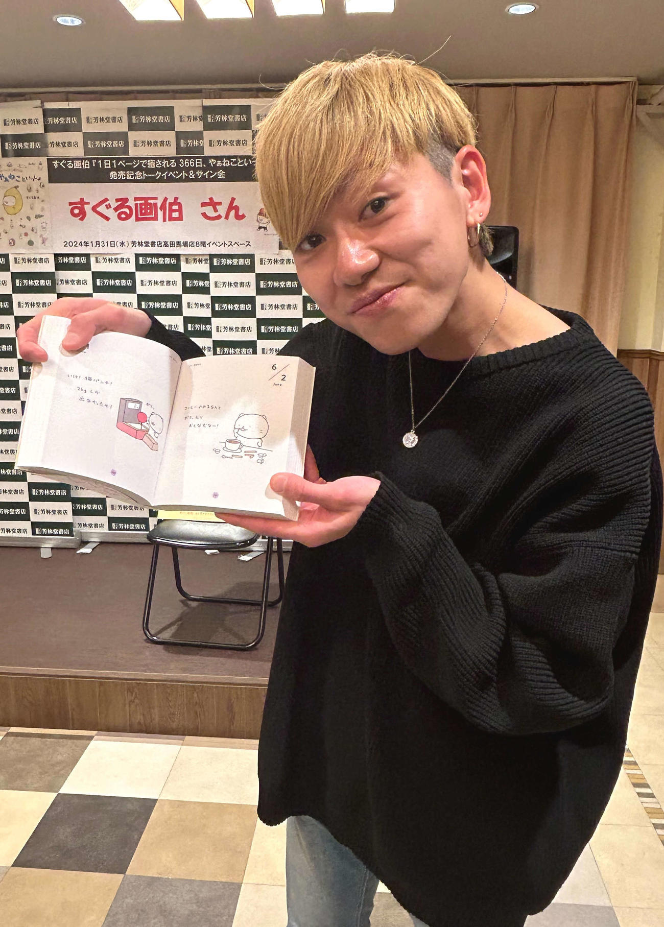 著書発売記念イベントを行い、お気に入りページをみせる、すぐる画伯（撮影・松尾幸之介）