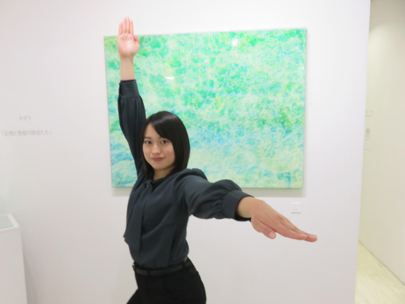 アート作品「光をたどる」の前で自衛隊体操の「統制」のポーズを決めるかざり