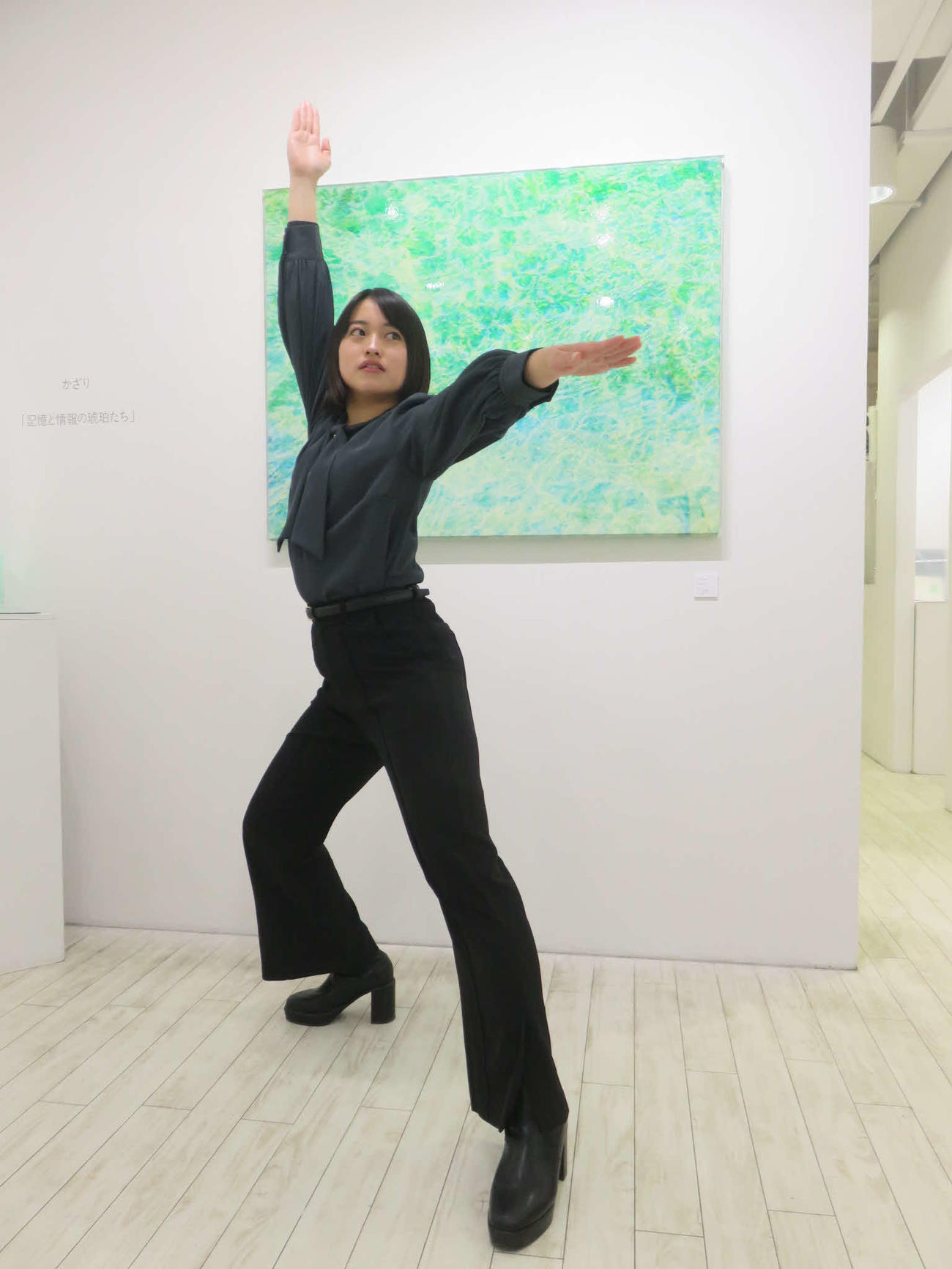 アート作品「光をたどる」の前で自衛隊体操の「統制」のポーズを決めるかざり