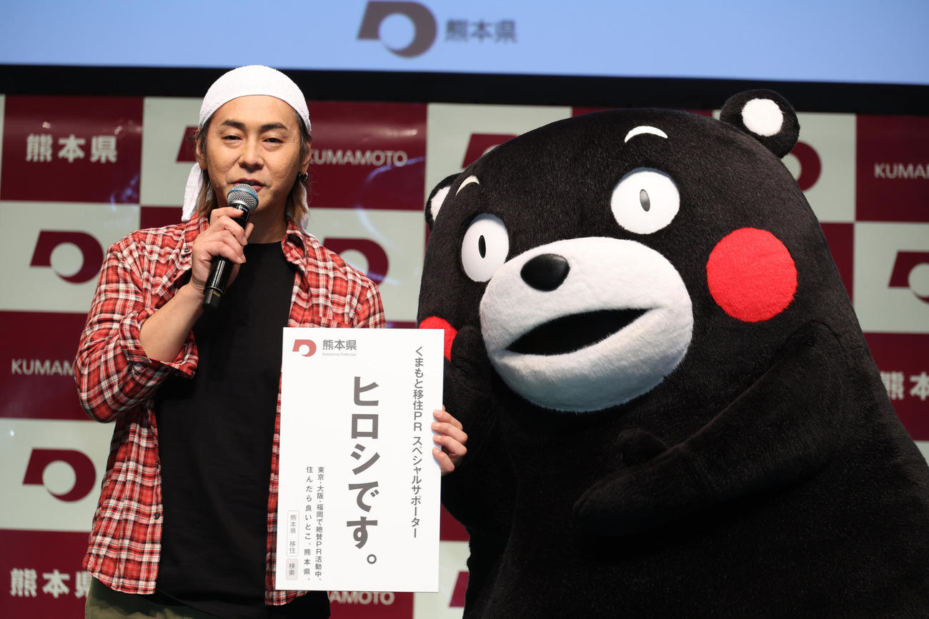 くまモン（右）から特大名刺を受け取るヒロシ（撮影・中島郁夫）