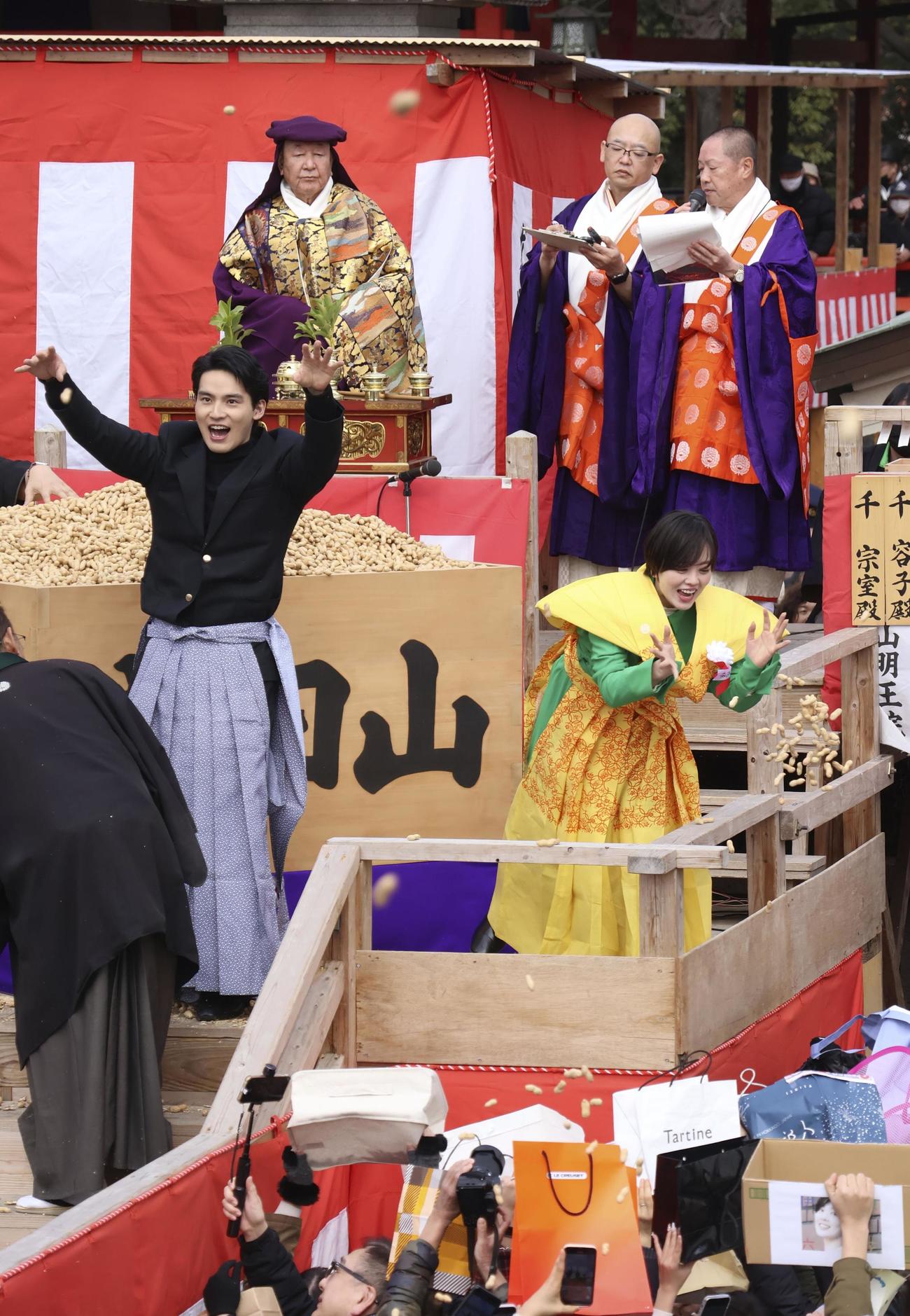 成田山大阪別院の節分祭で豆をまく、NHK連続テレビ小説「ブギウギ」出演者の水上恒司（手前左）、伊原六花（同右）ら（共同）