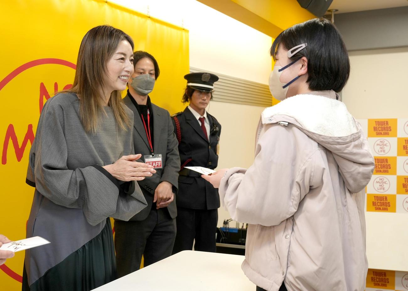ファン一人ひとりにサイン色紙を手渡す高岡早紀