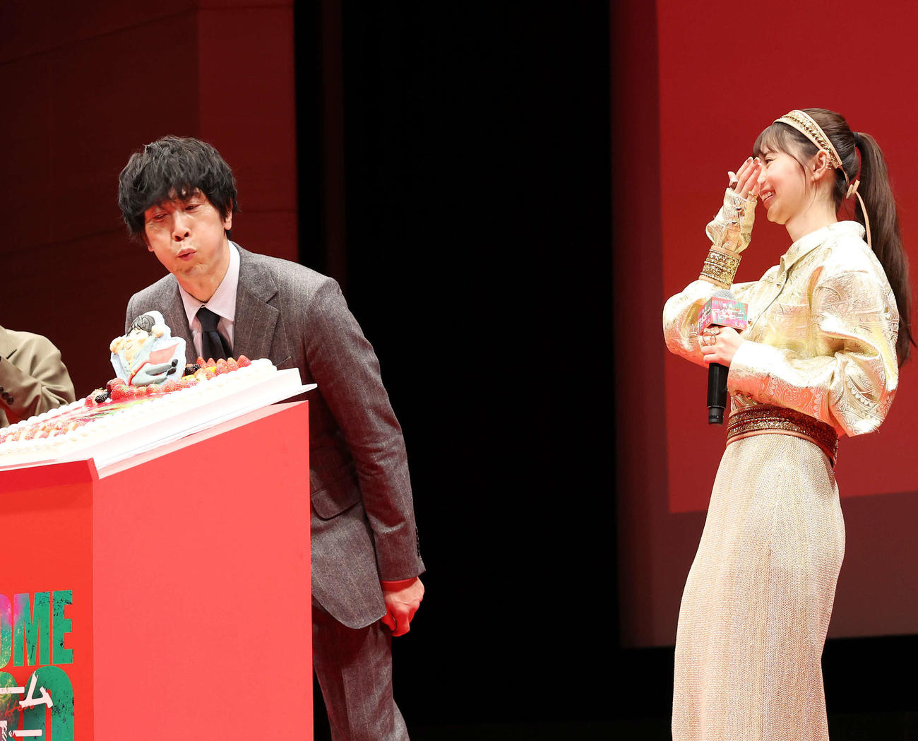 「映画　マイホームヒーロー」完成披露イベントで誕生日ケーキを消すそぶりを見せる佐々木蔵之介（左）と笑顔の齋藤飛鳥（撮影・宮地輝）