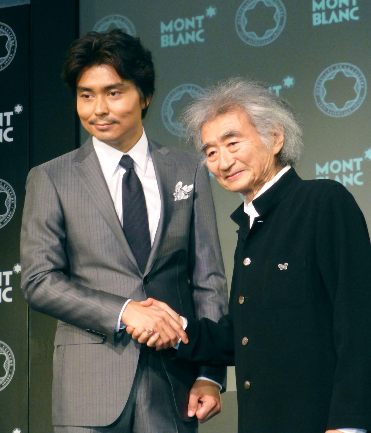 14年5月、モンブラン国際文化賞を受賞した小澤征爾さん（右）は長男征悦と握手