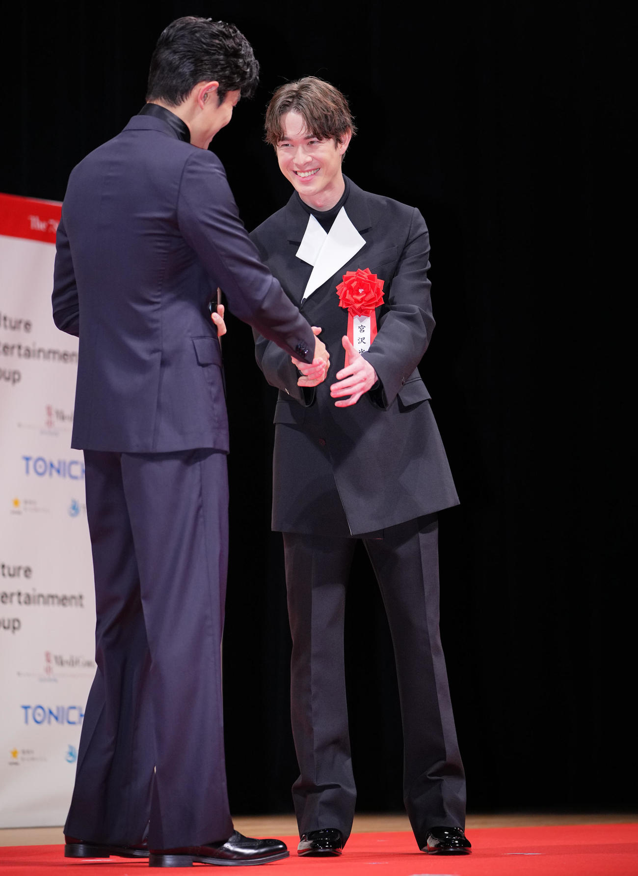 第78回毎日映画コンクールの俳優部門主演賞を受賞した鈴木亮平（左）を祝福する宮沢氷魚（撮影・垰建太）
