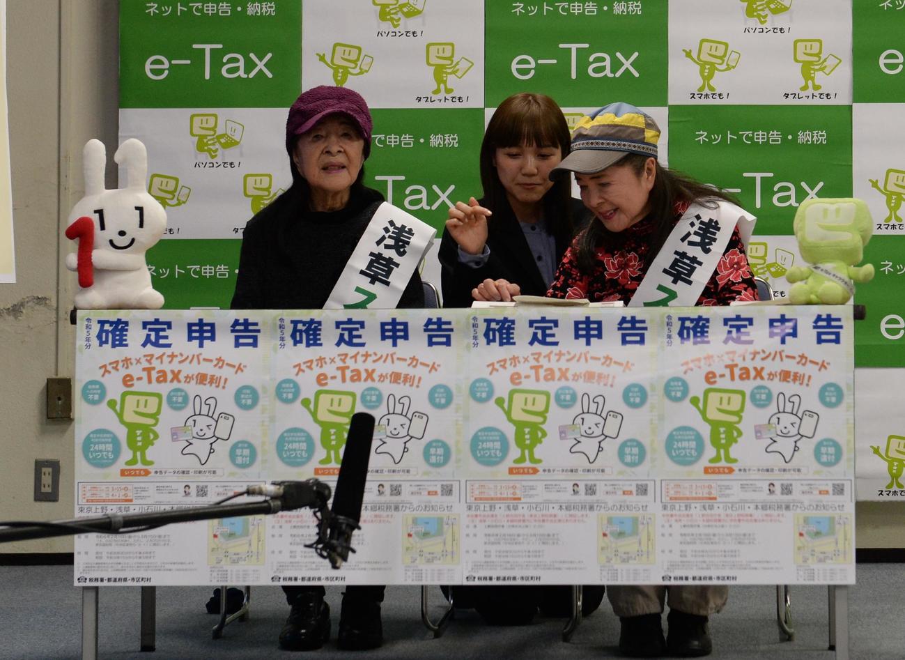 浅草税務署から「スマホ申告広報大使」を委嘱され、スマホで確定申告の作成体験をするこまどり姉妹。姉の栄子（左）と妹の敏子