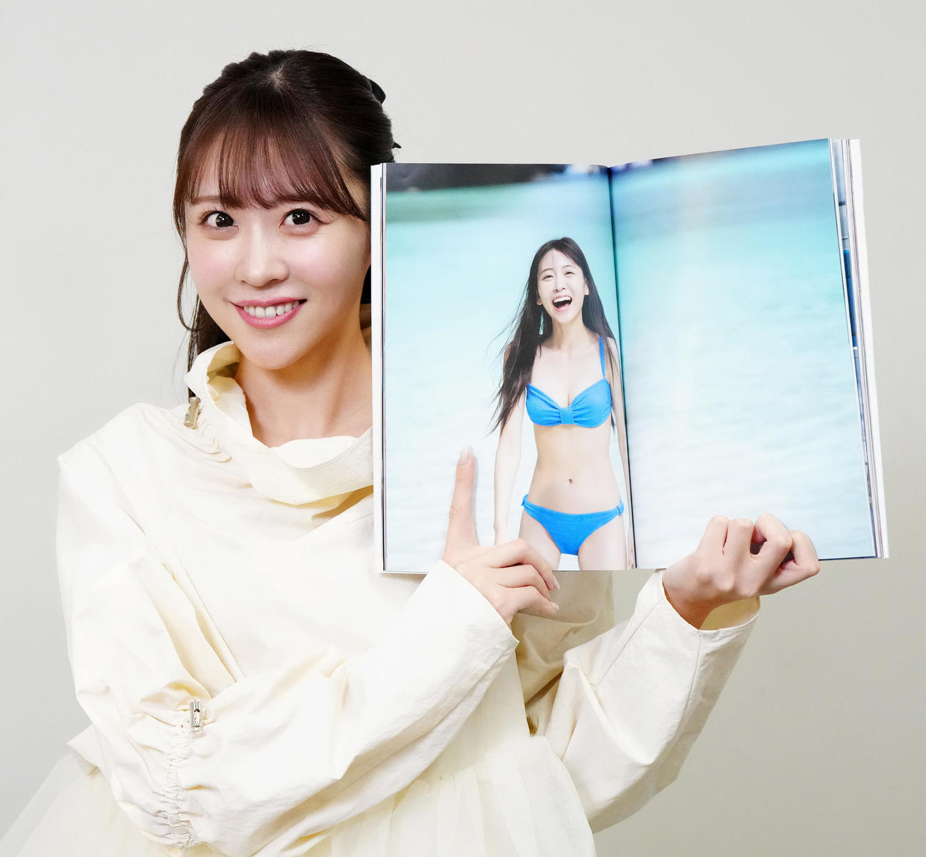 写真集のお気に入りの写真を見せるFRUITS ZIPPERの櫻井優衣（撮影・江口和貴）