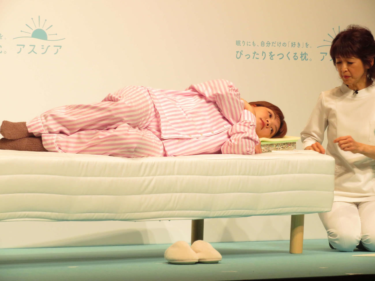 「アシスア枕」広告キャラクター発表会に出席し、山田朱織氏（右）に枕を調整してもらう野呂佳代