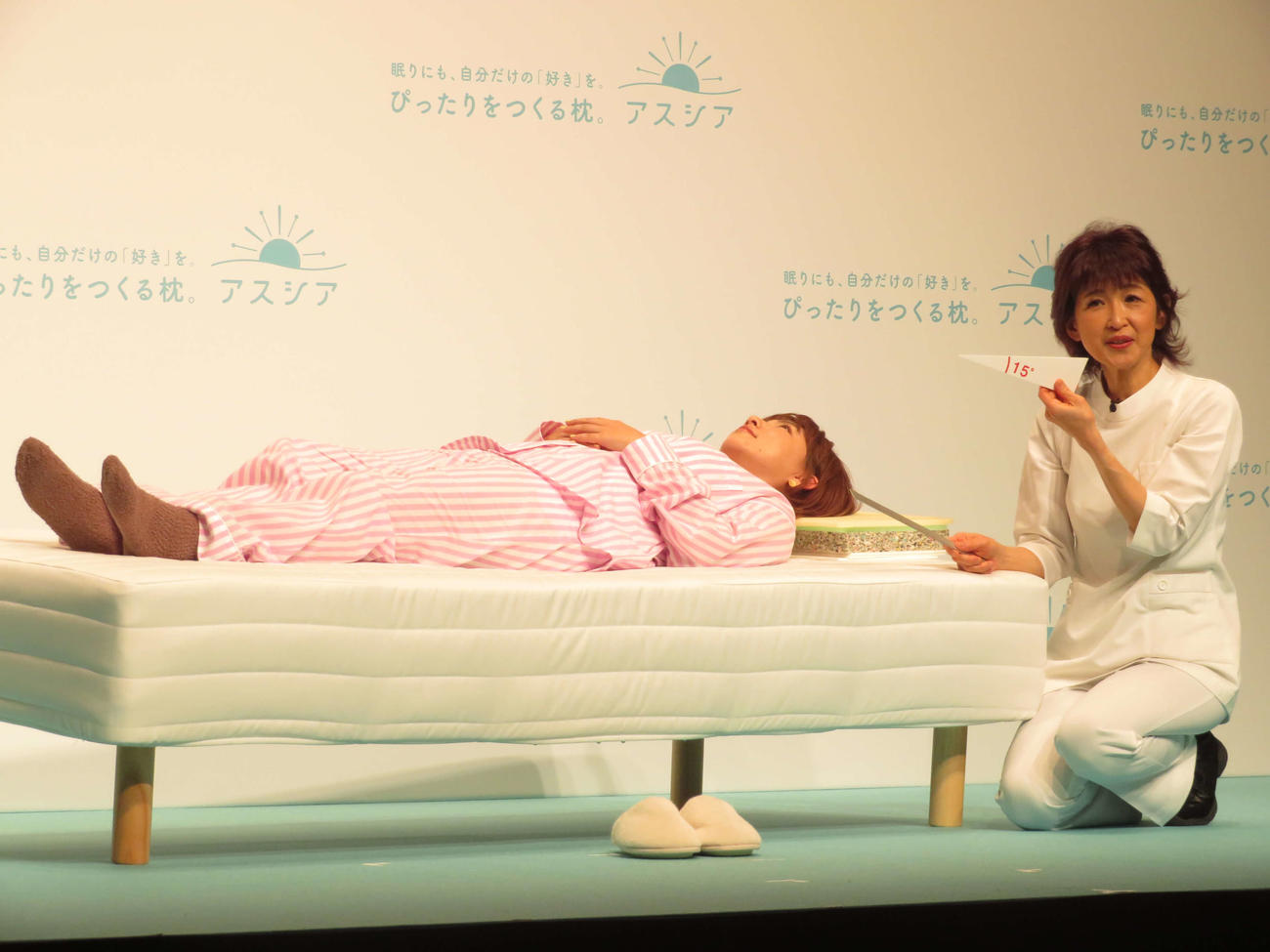 「アシスア枕」広告キャラクター発表会に出席し、山田朱織氏（右）に枕を調整してもらう野呂佳代