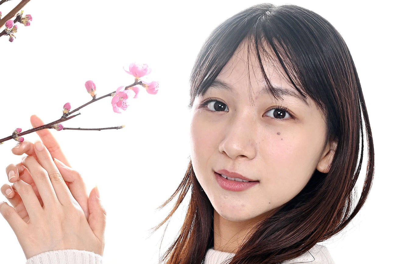 桃の花と写真に納まる杉本愛里（撮影・滝沢徹郎）