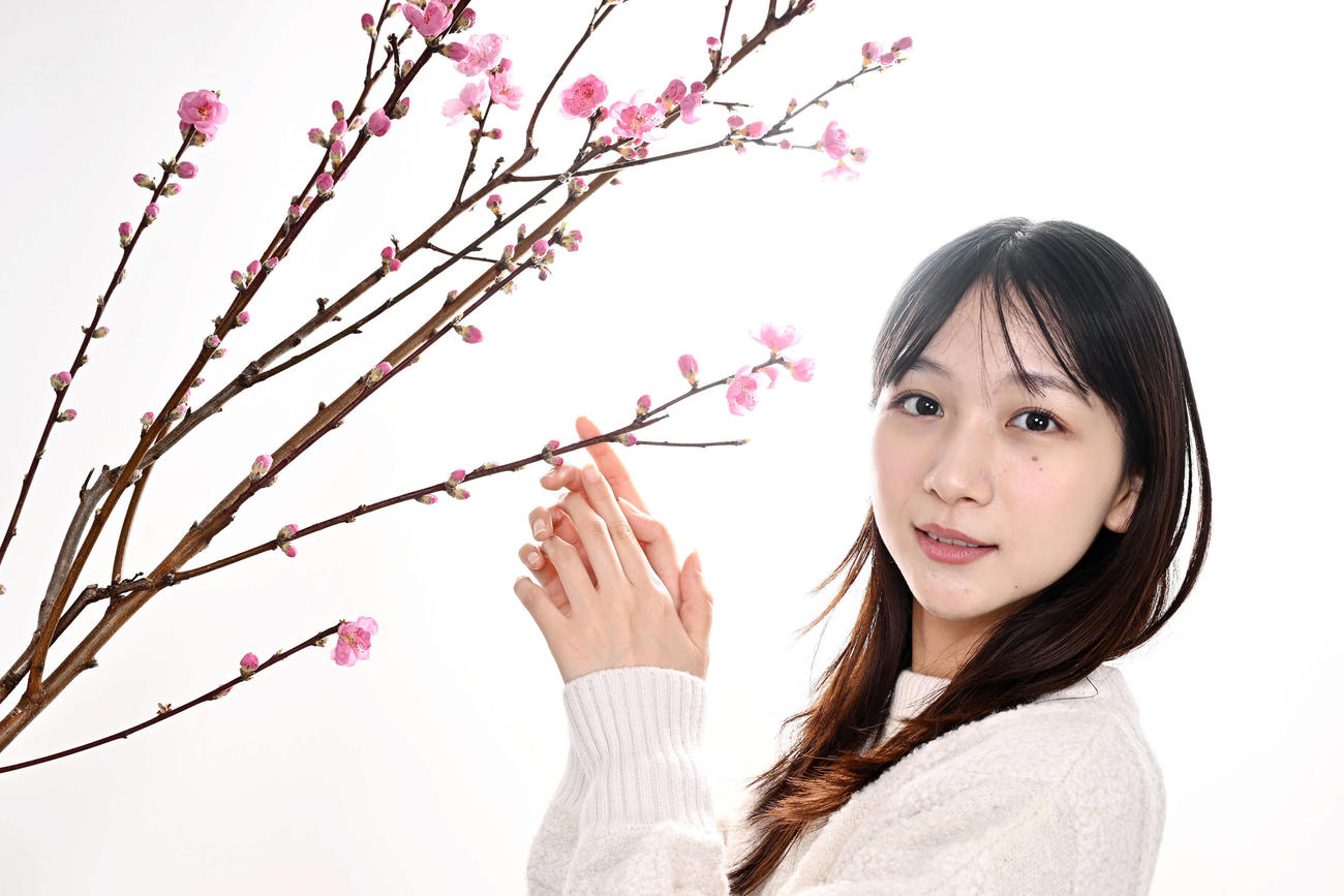 桃の花と写真に納まる杉本愛里（撮影・滝沢徹郎）