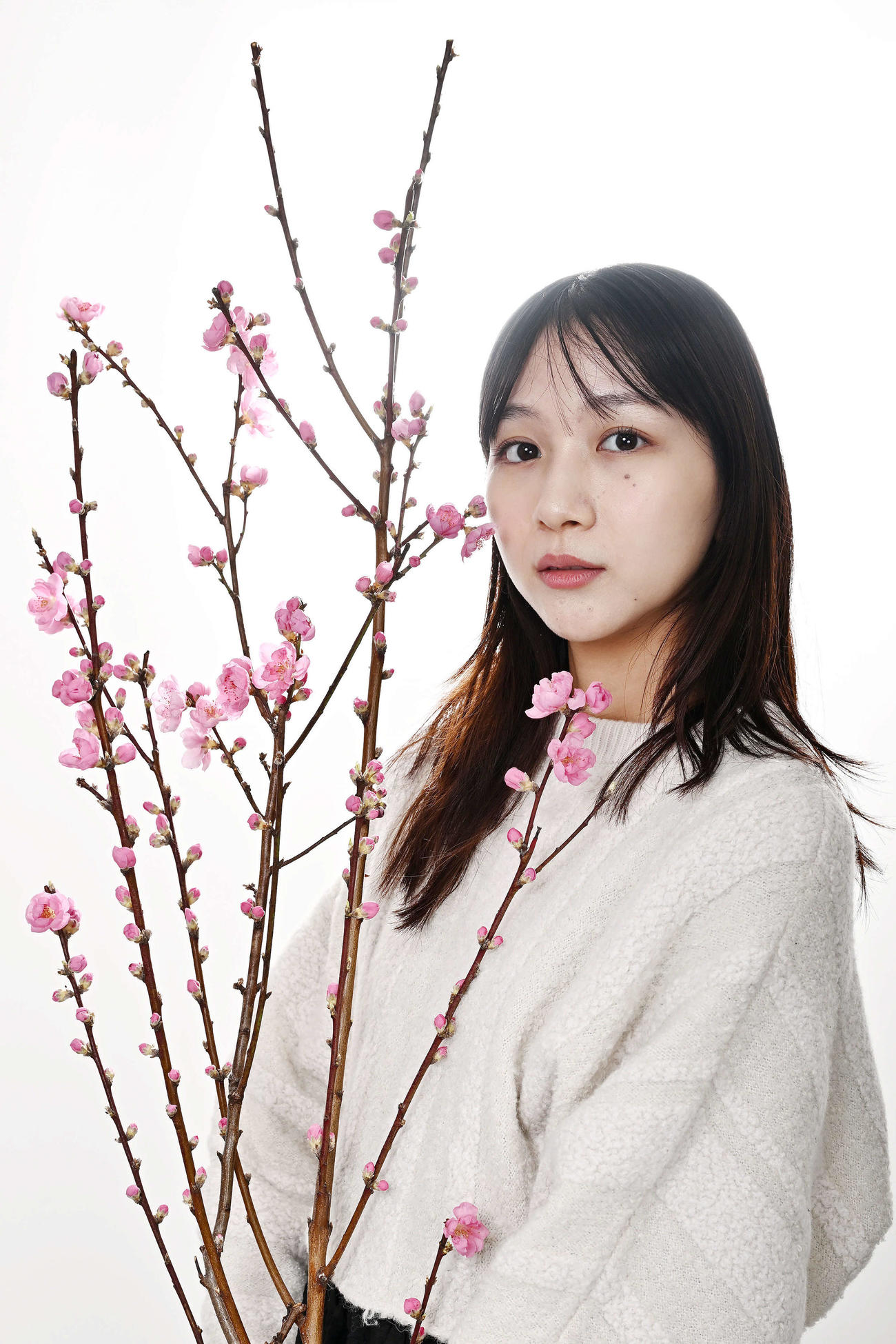 桃の花と写真に納まる杉本愛里（撮影・滝沢徹郎）