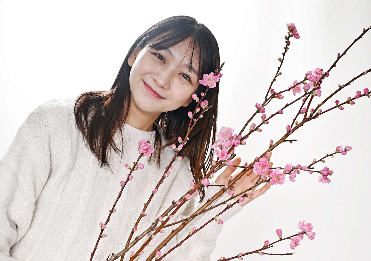桃の花と写真に納まる杉本愛里（撮影・滝沢徹郎）