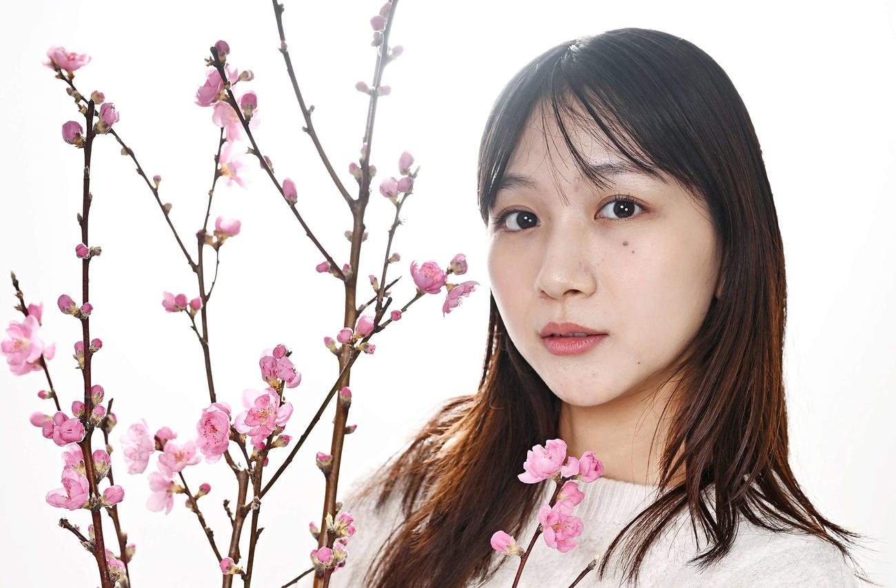 桃の花と写真に納まる杉本愛里（撮影・滝沢徹郎）