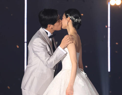 ウエディング姿でキスをするなこなこカップルのこーくん(左)となごみ(撮影・浅見桂子)