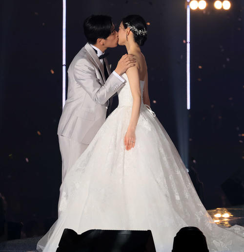 ウエディング姿でキスをするなこなこカップルのこーくん（左）となごみ（撮影・浅見桂子）
