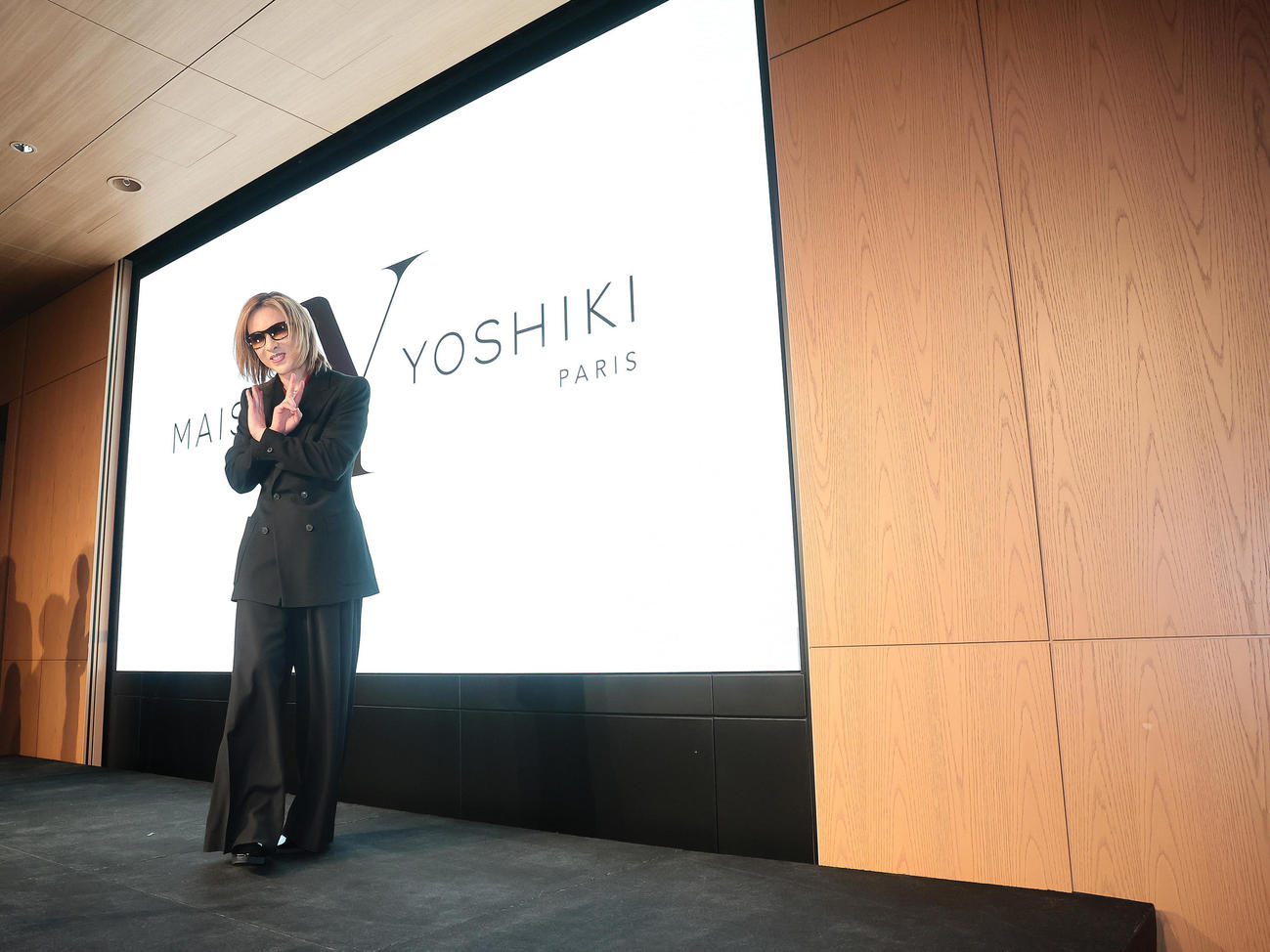 会見を終え、ポーズを決めながら降壇するYOSHIKI（撮影・足立雅史）