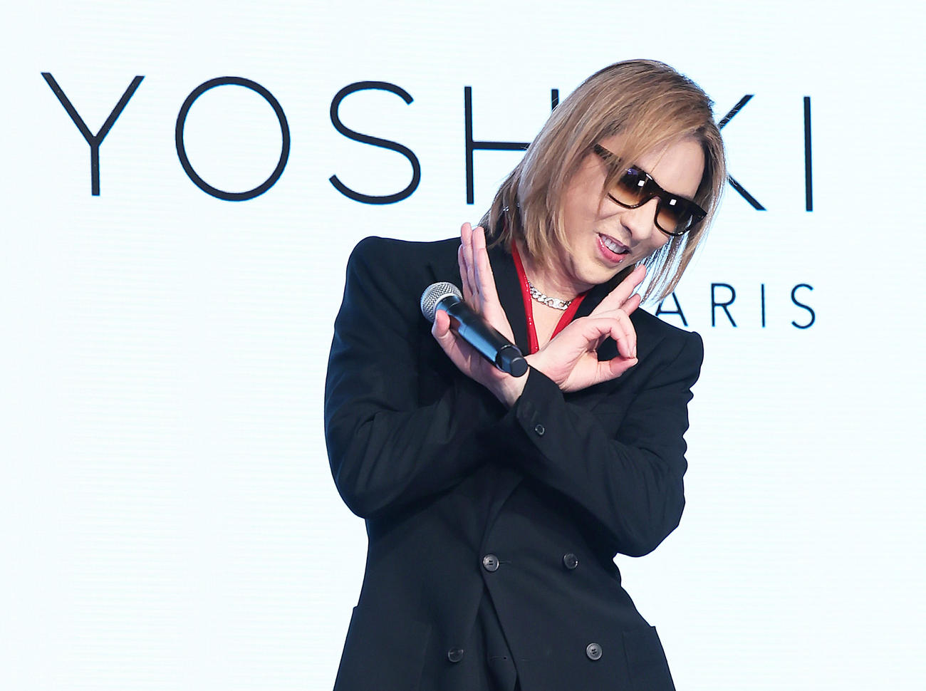 会見を終え、ポーズを決めながら降壇するYOSHIKI（撮影・足立雅史）