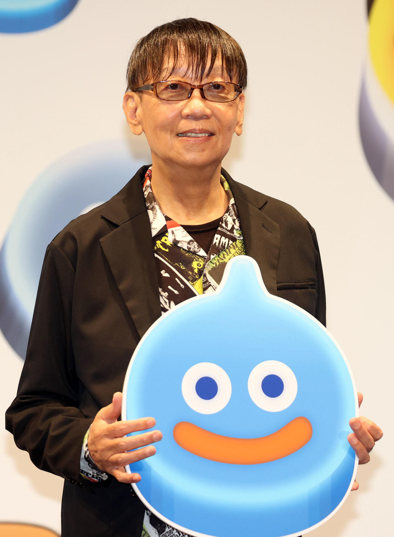 鳥山明さんがデザインしたドラゴンクエストのモンスター「スライム」のパネルを手にする堀井雄二氏（2022年撮影）